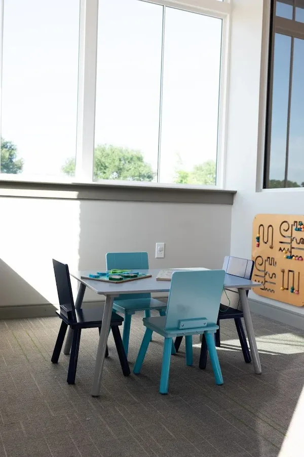 A small activity table and chairs by the window for tabletop work