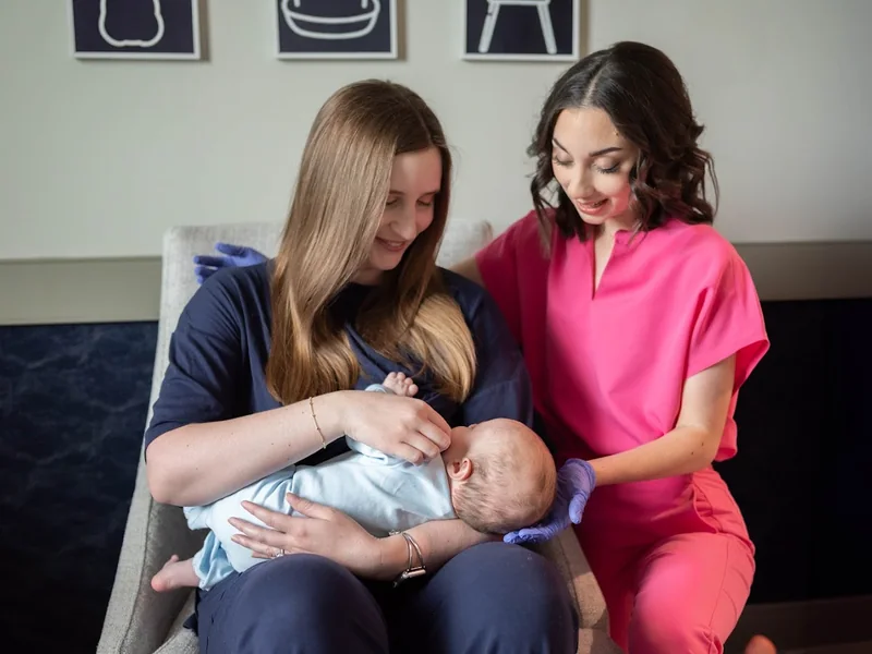 Speech therapist helping a mother with her newborn during a feeding visit