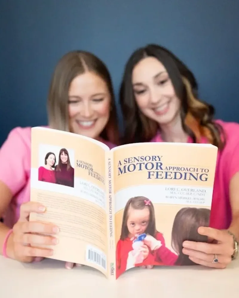Two Hope Therapy therapists reviewing a feeding reference together