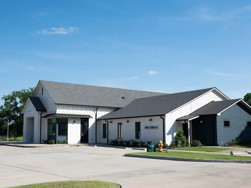 Wider view of the clinic building and the parking lot from the street